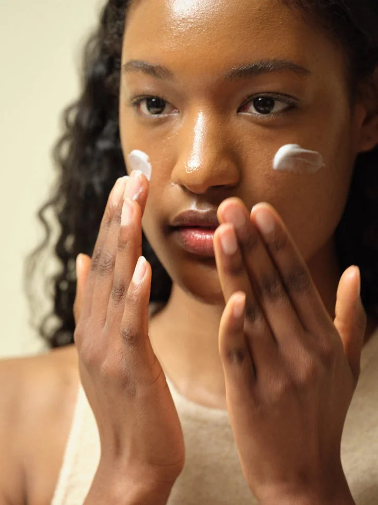 A hand applying a small amount of Beauty of Joseon Dynasty Cream to a face, highlighting its smooth, creamy consistency and dewy finish on the skin.