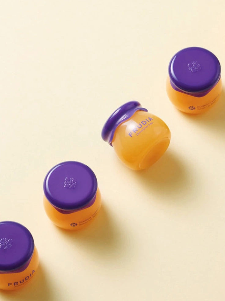 Collection of Frudia Blueberry Hydrating Honey Lip Balm jars, offering luxurious lip care.