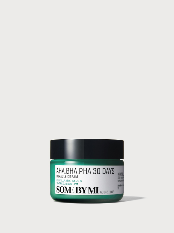 SOME BY MI AHA BHA PHA 30 Days Miracle Cream 60g jar on a smear of soothing green cream with tea tree leaves